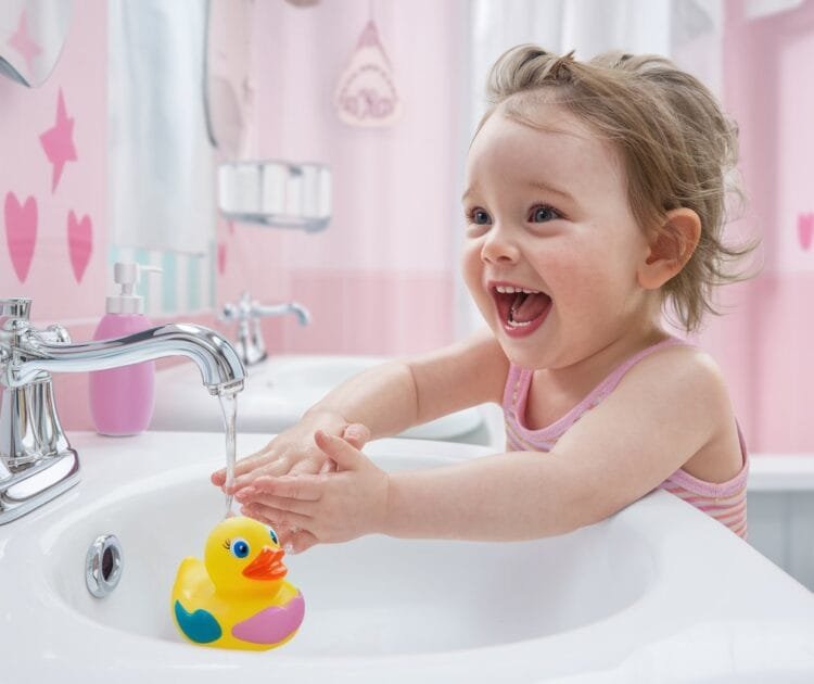 image of a child laughing and having fun while washing their hands
